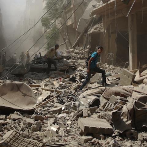 Syrians walk amid the rubble of destroyed buildings following reported air strikes by regime forces in the rebel-held area of Douma, east of the capital Damascus, on August 30, 2015. (ABD DOUMANY/AFP/Getty Images)