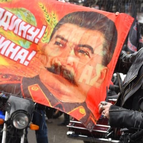 A Russian biker shows a banner depicting Joseph Stalin and reading a WWII slogan 'For the Motherland! For Stalin!' in Moscow on April 25, 2015. (DMITRY SEREBRYAKOV/AFP/Getty Images)