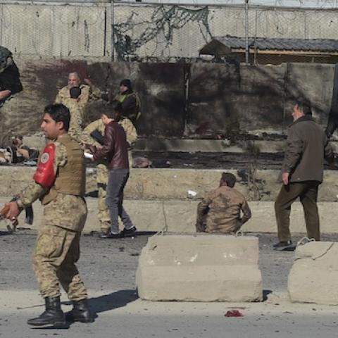Afghan security personnels gather as victims are treated at the site of a suicide car bomb next to a police base in Kabul on February 1, 2016. (SHAH MARAI/AFP/Getty Images)