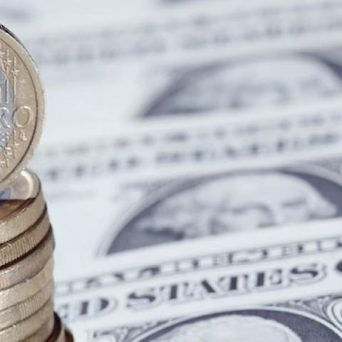 Euro coins sit on a display of one Dollar notes, on November 26, 2010 in London, England. (Dan Kitwood/Getty Images)