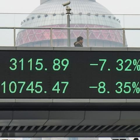 A man passes by electric screen showing Chinese shares decrease sharply to a halt point on January 7, 2016 in Shanghai, China. (ChinaFotoPress/Getty Images)