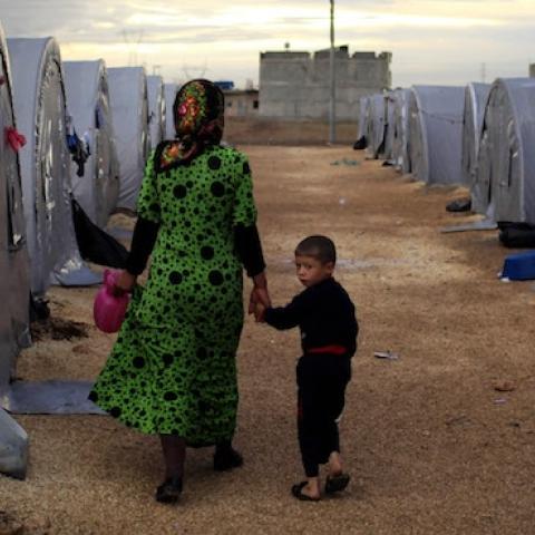 A Kurdish refugee mother and son from the Syrian town of Kobani walk beside their tent in a camp on the Turkish-Syrian border on October 19, 2014 in Sanliurfa, Turkey. (Gokhan Sahin/Getty Images)