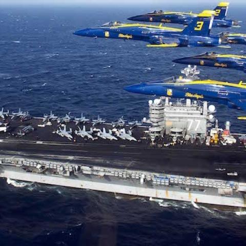 The U.S. Navy flight demonstration squadron, the Blue Angels, fly in the Delta Formation over the aircraft carrier USS George H.W. Bush off the Florida coast near Mayport Naval Station, Fla., in the Atlantic Ocean, Dec.10, 2013. (DoD/Released)