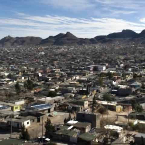 A young tattooed man stands on the hill overlooking the city of Juarez, Mexico. (Shaul Schwarz/Getty Images)