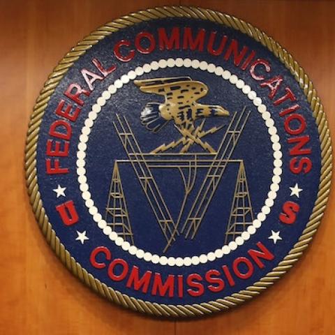 The seal of the Federal Communications Commission hangs behind commissioner Tom Wheeler's chair inside the hearing room at the FCC headquarters February 26, 2015 in Washington, DC. (Mark Wilson/Getty Images)