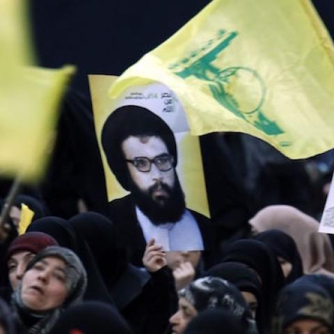 Supporters wave the flag of Lebanon and the Shiite movement Hezbollah alongside a poster of former Hezbollah leader Abbas al-Mussawi during a rally in Beirut on February 16, 2016. (ANWAR AMRO/AFP/Getty Images)