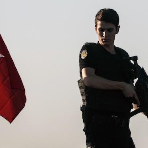 A Turkish anti riot police officer stands guard on a tank after a military position on the Bosphorus bridge was taken over in Istanbul on July 16, 2016. (OZAN KOSE/AFP/Getty Images)