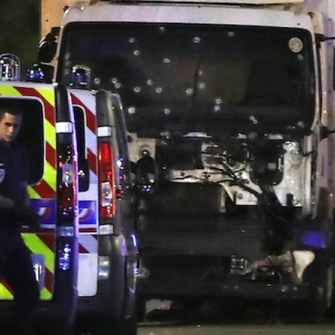 Police officers and rescue workers stand near a van that ploughed into a crowd leaving a fireworks display in the French Riviera town of Nice on July 14, 2016. (VALERY HACHE/AFP/Getty Images)