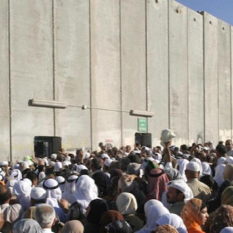 Palestinians gather at a check point on the outskirts of Bethlehem (Photo by MUSA AL-SHAER/AFP/Getty Images)
