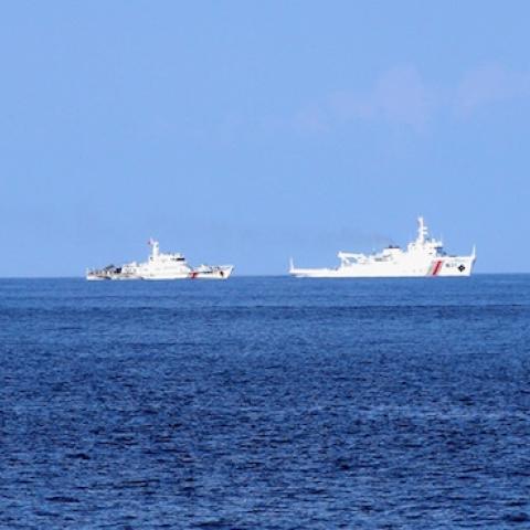 A Vietnamese fisheries surveillance force vessel (R) is chased by Chinese Maritime Police Bureau ships on May 27, 2014 (Photo by The Asahi Shimbun via Getty Images)