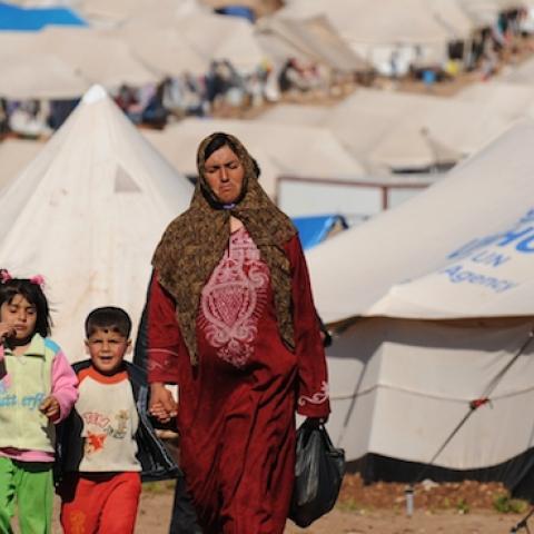Syrian internally displaced people walk in the Atme camp, along the Turkish border in the northwestern Syrian province of Idlib, on March 19, 2013. (BULENT KILIC/AFP/Getty Images)