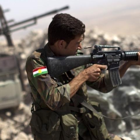 An Iraqi Kurdish Peshmerga fighter fires at Islamic-State (IS) militant positions, from his position on the top of Mount Zardak, about 25 kilometers east of Mosul on September 9, 2014. (JM LOPEZ/AFP/Getty Images)