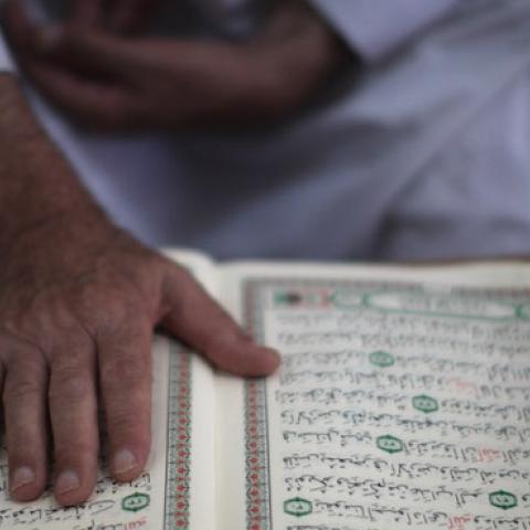 A mourner reads the Quran on August 17, 2011 in Gaza City, Gaza. (Christopher Furlong/Getty Images)