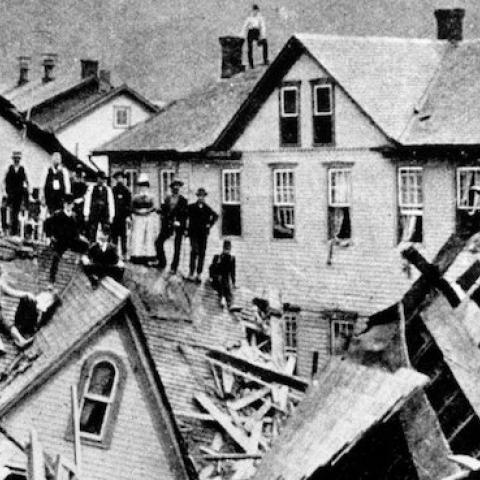 People stand atop a mass of destroyed houses that had been compressed by the force of floodwaters on May 31, 1889. (National Park Service)