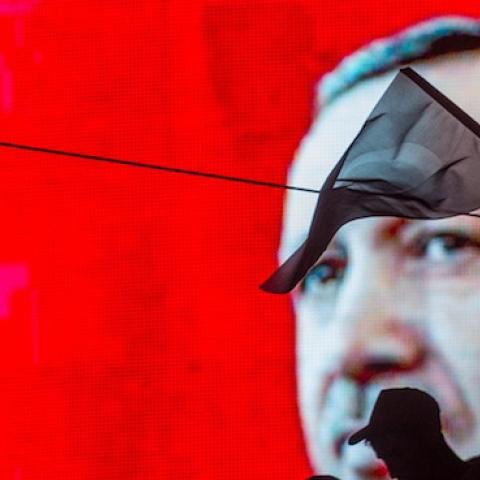 People wave Turkish flags in front of an electronic billboard displaying the face of President Recep Tayyip Erdogan at a rally on the streets of Kizilay Square on July 17, 2016 in Ankara, Turkey. (Chris McGrath/Getty Images)