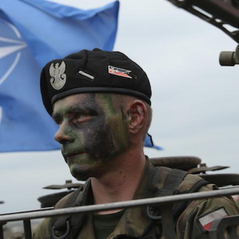 A soldier of the Polish Army sits in a tank as a NATO flag flies behind during the NATO Noble Jump military exercises of the VJTF forces on June 18, 2015 in Zagan, Poland. (Sean Gallup/Getty Images)