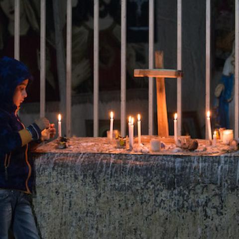 A Iraqi Christian boy lights candles inside a shrine in the grounds of Mazar Mar Eillia (Mar Elia) Catholic Church, on December 12, 2014 in Erbil, Iraq. (Matt Cardy/Getty Images)