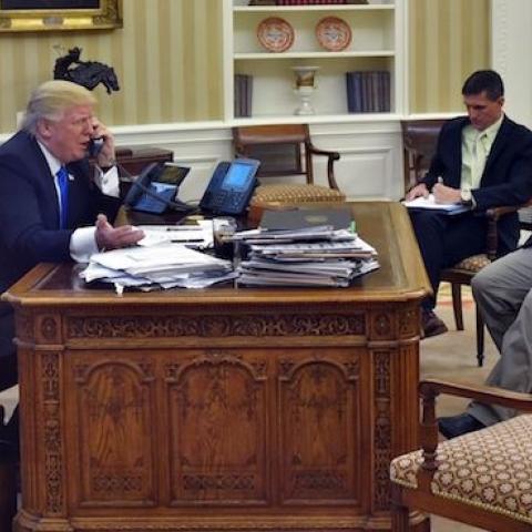 US President Donald Trump speaks on the phone with Australia's Prime Minister Malcolm Turnbull, with Chief Strategist Steve Bannon (R) and National Security Advisor Michael Flynn, from the Oval Office on January 28, 2017. (MANDEL NGAN/AFP/Getty Images)