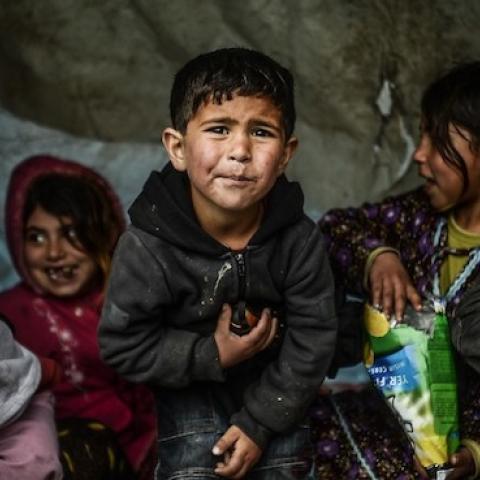 A Syrian refugee family from Aleppo, stay under a shelter during a rainy day on March 8, 2014, at Uskudar in Istanbul. (BULENT KILIC/AFP/Getty Images)