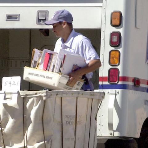A United States mail carrier loads his truck August 23, 2001 in Modesto, California. (Justin Sullivan/Getty Images)