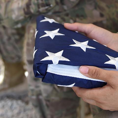 A US soldier holds the national flag ahead of a handover ceremony at Leatherneck Camp in Helmand province, Afghanistan, April 29, 2017 (WAKIL KOHSAR/AFP/Getty Images)