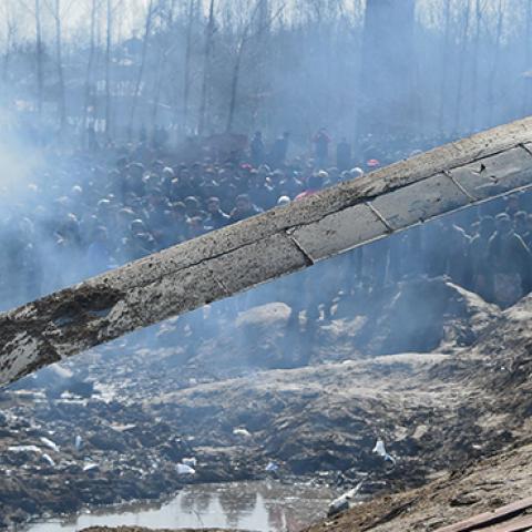 Indian soldiers and Kashmiri onlookers stand near the remains of an Indian Air Force helicopter after it crashed in Budgam district, outside Srinagar on February 27, 2019. (AUSEEF MUSTAFA/AFP/Getty Images)