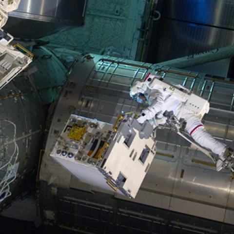 NASA astronaut Ronald Garan attached to the robotic arm Canadarm2 moves a failed ammonia pump module from a storage platform on the ISS to the cargo bay of the space shuttle Atlantis during a planned spacewalk July 12, 2011. (NASA via Getty Images)