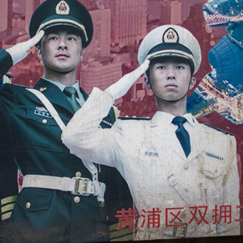 A man passes a military propaganda poster in Shanghai on March 5, 2017. (JOHANNES EISELE/AFP/Getty Images)