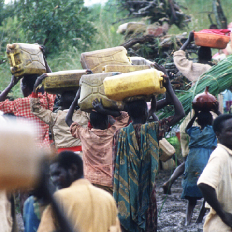 A crowd of refugees carry their belongings May 3, 1994 at the border of Rwanda and Tanzania. Hutu refugees have fled to Tanzania border across the Akagara River in order to escape reprisals by Tutsi rebels. (Scott Peterson/Liaison)