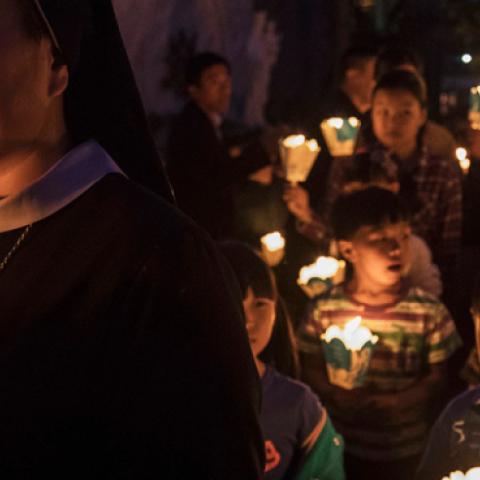Chinese Catholics hold candles at a mass on Holy Saturday during Easter celebrations at the government sanctioned West Beijing Catholic Church on April 15, 2017 in Beijing, China. (Kevin Frayer/Getty Images)