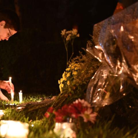 A woman kneels to place a candle outside the Tree of Life Synagogue after a shooting there left 11 people dead in the Squirrel Hill neighborhood of Pittsburgh on October 27, 2018. (Getty Images)