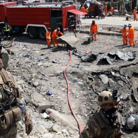 Afghan security forces walks as municipal workers gather to clean up near the crater from where a tractor packed with explosives exploded the night before at the Green Village in Kabul on September 3, 2019. (Getty Images)