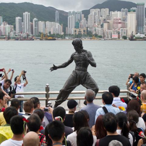 Fans gather around a statue of Bruce Lee to mark the 40th anniversary of his death, on the Avenue of the Stars in Hong Kong on July 20, 2013. Lee helped put Hong Kong on the movie world map. (ANTHONY WALLACE/Getty Images)