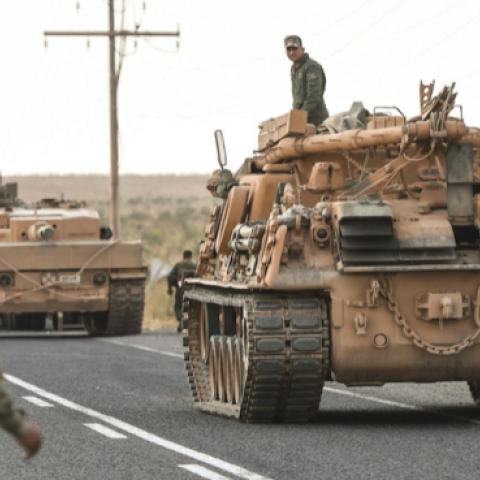 Turkish soldiers secure a road before army tanks start moving toward the Syrian border in Ceylanpinar, Turkey, on Oct. 18. (BURAK KARA/GETTY IMAGES)