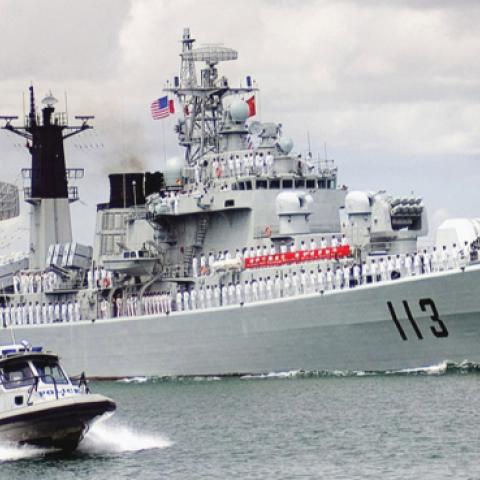 The Chinese Navy destroyer Qingdao (DDG 113) transit through the Pearl Harbor channel while being escorted by a harbor patrol boat as it arrives for a routine port visit. (U.S. Navy photo, released)