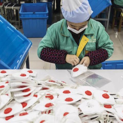 An employee works on the assembly line to make protective masks at a factory in Shanghai, China, on Jan. 31.
