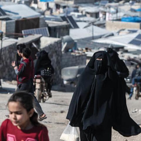 Displaced Syrians walk on the road at village of Atmeh which hosts nearly 2 million displaced Syrians on February 20, 2020 in Idlib, Syria.