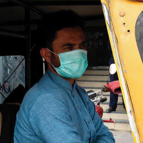 An auto-rickshaw driver wears a protective facemask as a prevention measure against the  COVID-19 coronavirus as he wait for passengers along a street in Quetta on February 27, 2020 as Pakistan has detected its first two cases of novel coronavirus. - Paki