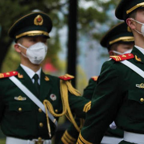 Chinese soldiers wearing protective masks march at the People's Square on April 04, 2020 in Shanghai, China