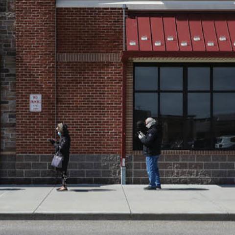 People line up exactly 6-feet-apart in front of a Westwood Wegmans store on Apr. 4, 2020 in Westwood, MA. With the coronavirus expected to peak in mid-April, grocery stores have cracked down on social distancing guidelines throughout the Boston area.