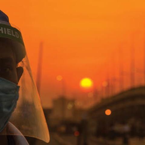 An Indian volunteer wearing a protective mask and face shield stands guard on a road, as India remains under an extended lockdown due to COVID-19 on May 6, 2020 in New Delhi, India. 