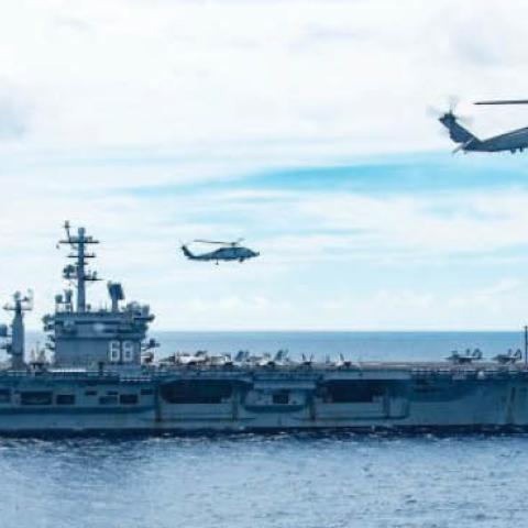 MH-60R Sea Hawks attached to Helicopter Maritime Strike Squadron HSM-77 (the “Saberhawks”) hover in formation between the aircraft carrier USS Ronald Reagan (foreground) and USS Nimitz while under way in the South China Sea, July 7, 2020. The Nimitz and R