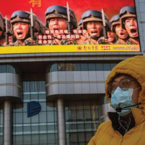 A bicyclist rides past government propaganda in Beijing, April 20.