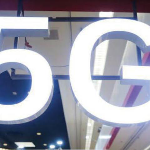 Attendees and workers chat beneath a '5G' logo at the Quectel booth at CES 2020 at the Las Vegas Convention Center on January 8, 2020 in Las Vegas, Nevada.