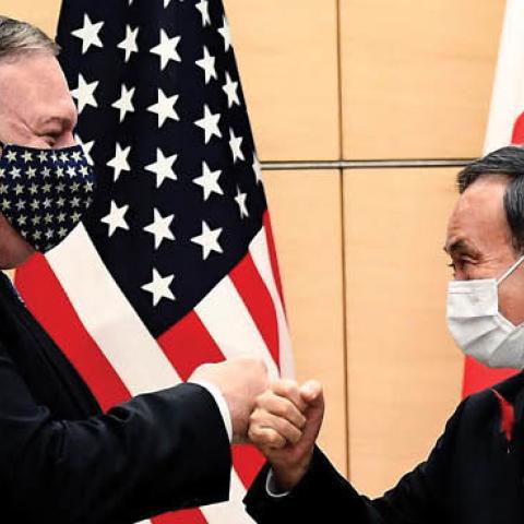 Japan's Prime Minister Yoshihide Suga and Secretary of State Mike Pompeo (L) bump fists as they meet at the prime minister's office in Tokyo on Tuesday.