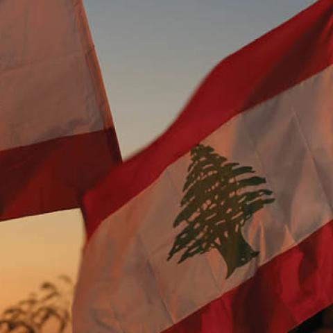 People wave Lebanese flags and chant to mark the one-year anniversary of anti-government protests on October 17, 2020 in Beirut, Lebanon.
