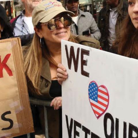 Pedestrians watch the 100th annual Veterans Day parade in New York, Nov. 11, 2019.