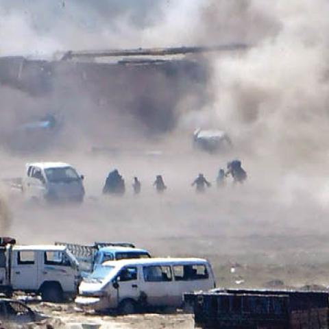 People are seen fleeing as heavy smoke rises above the Islamic State (IS) group's last remaining position in the village of Baghouz during battles with the Syrian Democratic Forces (SDF)