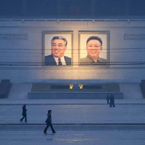Pedestrians walk past portraits of late North Korean leaders Kim Il-sung and Kim Jong-il across Kim Il-sung square in Pyongyang on December 3, 2018. (Ed Jones/AFP)