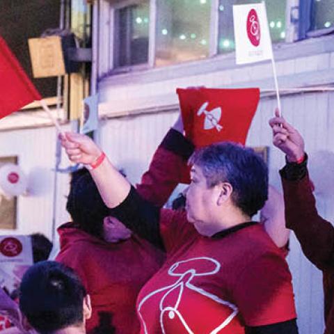 Members of the IA (Inuit Ataqatigiit) party wave party flags as they celebrate following the exit polls results of the legislative election in Nuuk, on April 6, 2021 (Photo by EMIL HELMS/Ritzau Scanpix/AFP via Getty Images)